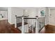 Hallway with dark wood floors, staircase with black railings, and white trim at 5755 Riley Rd, Cumming, GA 30028