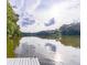 Tranquil lake view from the edge of a dock, showcasing calm waters and lush greenery on the opposite shore at 5755 Riley Rd, Cumming, GA 30028