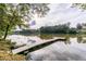 Scenic lake view featuring a wooden dock with a built-in bench, ideal for relaxing and enjoying nature at 5755 Riley Rd, Cumming, GA 30028
