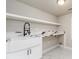 This clean and functional laundry room has a large basin sink, white cabinets, and countertop at 5755 Riley Rd, Cumming, GA 30028