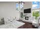 Bright living room with fireplace, tall windows, dark floors, white sofa and chairs at 5755 Riley Rd, Cumming, GA 30028