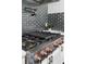 Professional style range with cooktop griddle, pot filler, and subway tile backsplash at 5755 Riley Rd, Cumming, GA 30028