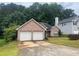 Charming brick home featuring a two-car garage and a well-maintained front lawn and lush green trees at 7513 Sugarcreek Dr, Riverdale, GA 30296