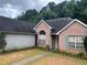 Brick home with a well-kept lawn and an inviting entrance, surrounded by lush greenery, creating a serene setting at 7513 Sugarcreek Dr, Riverdale, GA 30296