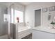 Bright bathroom featuring a soaking tub, glass enclosed shower, and white cabinets at 137 Prominence Ct, Canton, GA 30114