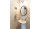 Cozy half bathroom with pedestal sink, oval mirror, and neutral decor at 137 Prominence Ct, Canton, GA 30114