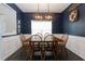 Dining room with dark blue walls, wainscoting, modern light fixture and seating for six at 137 Prominence Ct, Canton, GA 30114