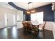 Dining room with dark blue walls, wainscoting, modern light fixture and seating for six at 137 Prominence Ct, Canton, GA 30114