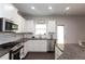 Bright kitchen featuring white cabinets, granite countertops, stainless steel appliances, and modern fixtures at 137 Prominence Ct, Canton, GA 30114