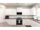 Close-up of the kitchen with white cabinets, stainless steel appliances, and granite countertops at 137 Prominence Ct, Canton, GA 30114