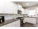 Well-lit kitchen featuring white cabinets, granite countertops, stainless steel appliances, and subway tile backsplash at 137 Prominence Ct, Canton, GA 30114