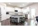 Modern white kitchen featuring a gray granite countertop island with barstool seating and stainless appliances at 137 Prominence Ct, Canton, GA 30114