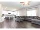 Spacious living room with gray sectional couch next to the modern white kitchen and dark wood floors at 137 Prominence Ct, Canton, GA 30114