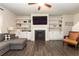 Spacious living room with a cozy gray sectional sofa, fireplace, built-in shelves, and hardwood flooring at 137 Prominence Ct, Canton, GA 30114