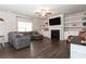 Spacious living room with a cozy gray sectional sofa, fireplace, built-in shelves, and hardwood flooring at 137 Prominence Ct, Canton, GA 30114