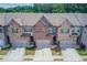 Overhead view of brick townhomes with attached garages and landscaping in a suburban neighborhood at 2005 Hamilton Creek Pkwy, Dacula, GA 30019