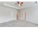 This bedroom boasts tray ceilings, plush carpeting, and multiple doors for easy access at 2005 Hamilton Creek Pkwy, Dacula, GA 30019