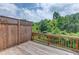 Wooden deck with railing and partial privacy screen, offering serene views of the surrounding lush greenery at 2005 Hamilton Creek Pkwy, Dacula, GA 30019
