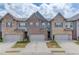 Charming townhome featuring a brick facade, attached garage, and well-manicured landscaping at 2005 Hamilton Creek Pkwy, Dacula, GA 30019