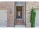 Inviting front entrance with brick steps leading to a glass-paneled front door of a townhome at 2005 Hamilton Creek Pkwy, Dacula, GA 30019