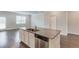 Kitchen island featuring granite countertop and stainless steel dishwasher open to the living area at 2005 Hamilton Creek Pkwy, Dacula, GA 30019