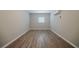 Neutral bedroom featuring wood-look floors, bright window, and in-wall air conditioner unit at 2233 Cherokee Valley Dr, Lithonia, GA 30058