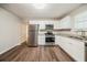 Updated eat-in kitchen features stainless steel appliances, granite counters, white cabinets and vinyl floors at 2233 Cherokee Valley Dr, Lithonia, GA 30058