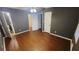 Spacious bedroom with hardwood floors and neutral colored walls, several doors, and a ceiling fan with lights at 3873 Jane Marie Ln, Decatur, GA 30035