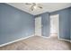 Cozy bedroom with blue walls, neutral carpet, ceiling fan, and a closet at 4753 Klondike Cv, Lithonia, GA 30038