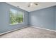 Serene bedroom with a large window offering natural light, neutral carpet and ceiling fan at 4753 Klondike Cv, Lithonia, GA 30038