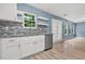 Modern kitchen features white cabinets, granite countertops, stainless steel appliances and stylish backsplash at 4753 Klondike Cv, Lithonia, GA 30038