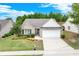 Well-maintained home featuring a brick facade, manicured lawn, mature landscaping, and a two-car garage at 936 Village View Cir, Loganville, GA 30052