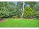 Lush backyard featuring expansive green lawn and mature trees with a bench on the left at 2676 Varner Ne Dr, Atlanta, GA 30345