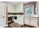 Bright laundry room with white cabinetry, sink, and washer/dryer set, near a window at 2676 Varner Ne Dr, Atlanta, GA 30345