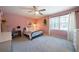 Bright bedroom with light pink walls, a ceiling fan, desk, and plenty of natural light at 4970 Lost Mountain Nw Trce, Kennesaw, GA 30152