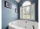 Soaking tub with shuttered windows and decorative accents and neutral wall paint at 5418 Amity Dr, Powder Springs, GA 30127