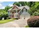 Charming two-story home features a brick facade, a well-manicured lawn, and an attached two-car garage at 5418 Amity Dr, Powder Springs, GA 30127