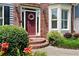 Inviting front entrance featuring a red door, brick steps, and lush landscaping with blooming flowers at 5418 Amity Dr, Powder Springs, GA 30127