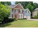 Charming two-story home featuring a brick facade, well-manicured lawn, and an attached two-car garage at 5418 Amity Dr, Powder Springs, GA 30127