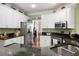 Granite countertops, stainless appliances, and white cabinets are featured in this kitchen design at 5418 Amity Dr, Powder Springs, GA 30127