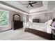 Spacious main bedroom with a decorative trey ceiling and large windows with wooded views at 5418 Amity Dr, Powder Springs, GA 30127