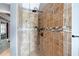 Walk-in shower featuring neutral tile with decorative accent, and dark hardware at 5418 Amity Dr, Powder Springs, GA 30127
