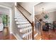 Interior view of a staircase with wood treads, white risers, and an adjacent dining room at 5418 Amity Dr, Powder Springs, GA 30127