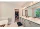 Main bathroom featuring double vanity, soaking tub, and walk-in closet at 816 S Columbia Dr, Decatur, GA 30030