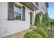 Close-up of the entrance to a two-story home showcasing white brick, dark shutters, and lush landscaping at 816 S Columbia Dr, Decatur, GA 30030