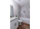 Bathroom vanity with granite countertops next to a bathtub with gray-and-white marble tile at 909 Shiloh Ridge Nw Run, Kennesaw, GA 30144