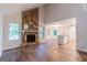 Open-concept living area with stone fireplace, hardwood floors, and a kitchen island in the background at 909 Shiloh Ridge Nw Run, Kennesaw, GA 30144
