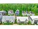 Aerial view of new construction neighborhood, with lush trees surrounding the homes, and pond in the community at 10862 Serenbe Ln, Chattahoochee Hills, GA 30268