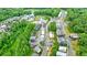 Aerial view of a neighborhood featuring modern farmhouse-style homes with grey facades and metal roofs surrounded by trees at 10862 Serenbe Ln, Chattahoochee Hills, GA 30268