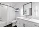 Bright bathroom featuring modern black hexagon floor tile, a shower-tub combo, and a vanity with white countertops at 10862 Serenbe Ln, Chattahoochee Hills, GA 30268